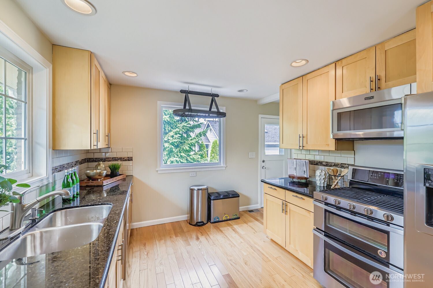 23001 Brier Road Brier, WA 98036 - Photo 8 of 28 a kitchen with stainless steel appliances a sink a stove a refrigerator cabinets and a window
