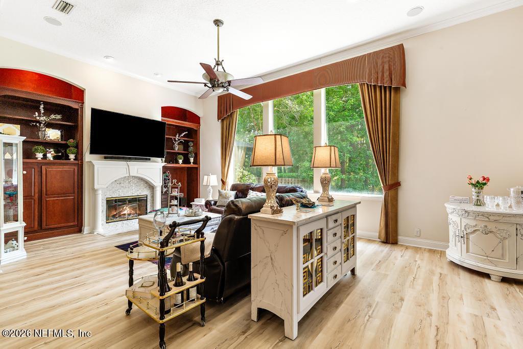 7843 Mt Ranier Drive Jacksonville, FL 32256 - Photo 38 of 116 a living room with furniture a fireplace and a flat screen tv