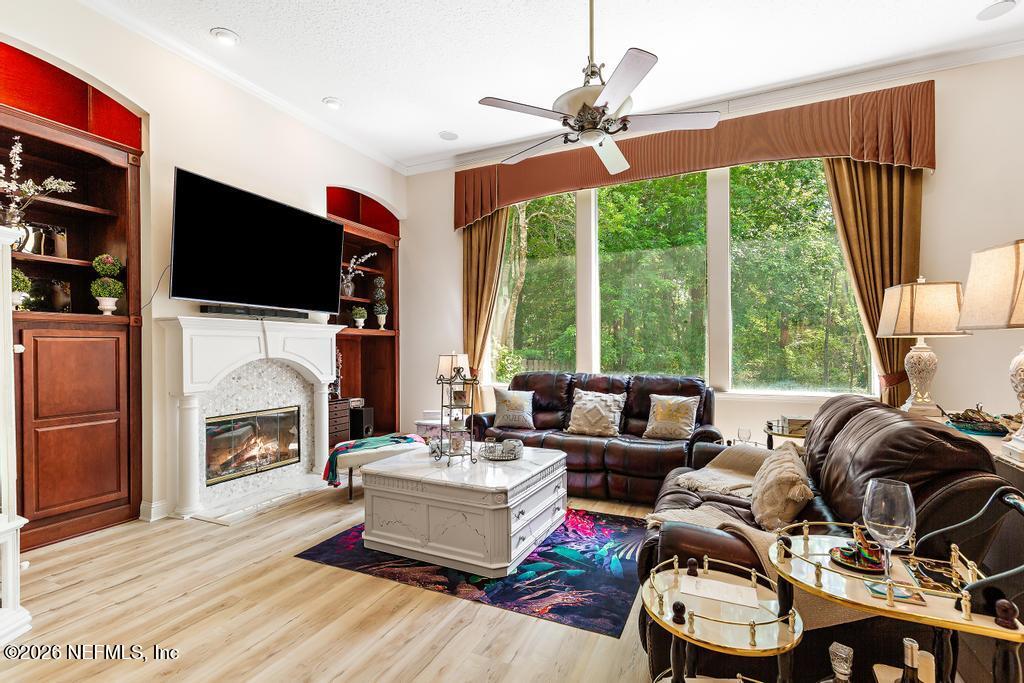 7843 Mt Ranier Drive Jacksonville, FL 32256 - Photo 39 of 116 a living room with furniture a fireplace and a flat screen tv