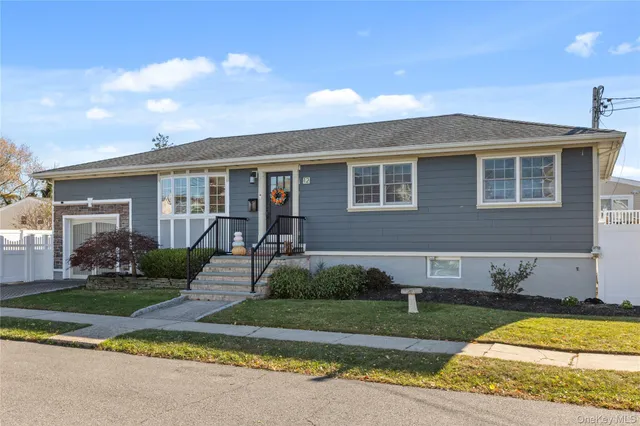 a front view of a house with a yard and potted plants