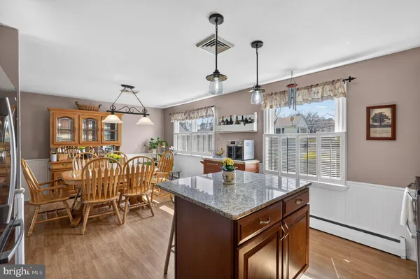 a kitchen with stainless steel appliances granite countertop a kitchen island a stove a table and chairs