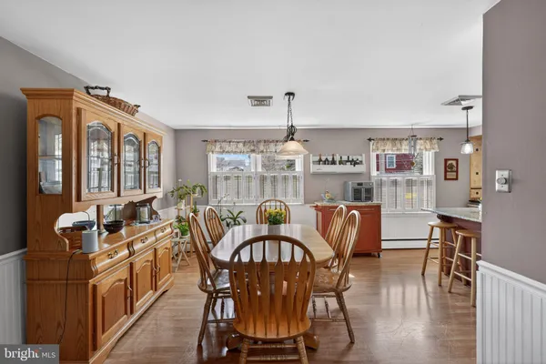 a dining room with furniture a chandelier and wooden floor