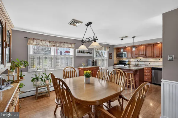 a dining room with furniture a chandelier and wooden floor