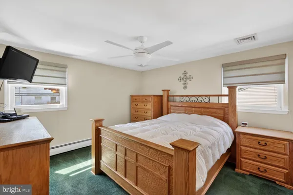 a bedroom with a bed a dresser and flat screen tv