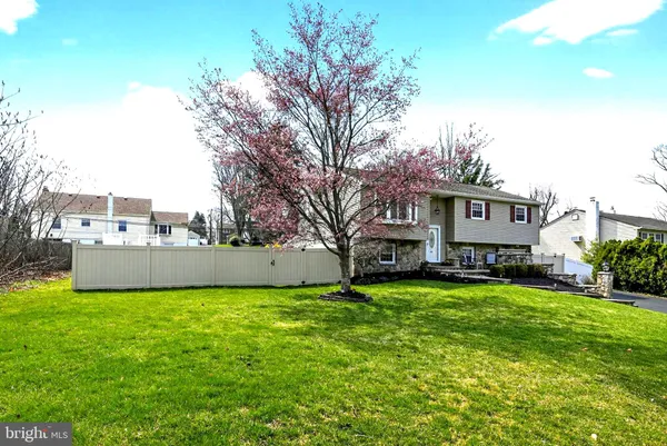 a view of a house with a big yard and large trees