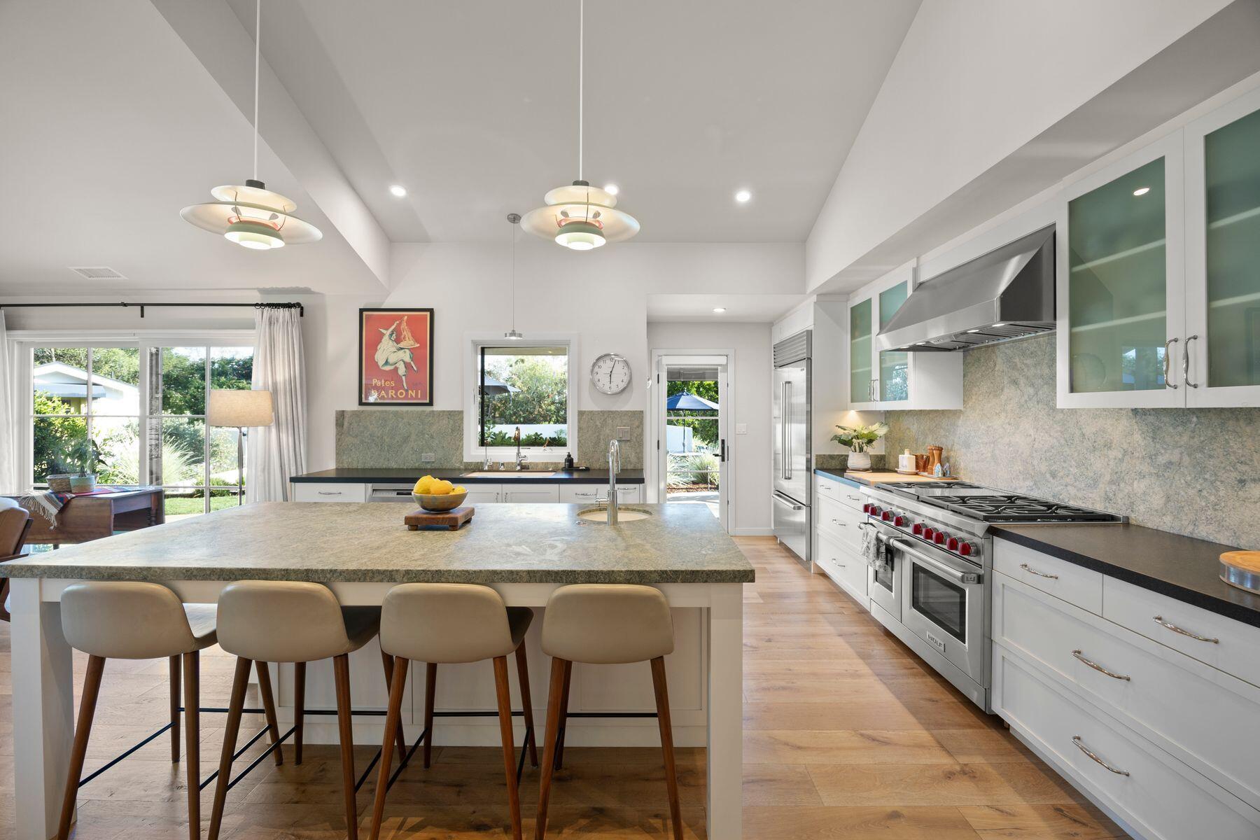 10929 Encino Drive Oak View, CA 93022 - Photo 11 of 50 a kitchen with stainless steel appliances granite countertop a stove top oven a sink dishwasher a dining table and chairs with wooden floor