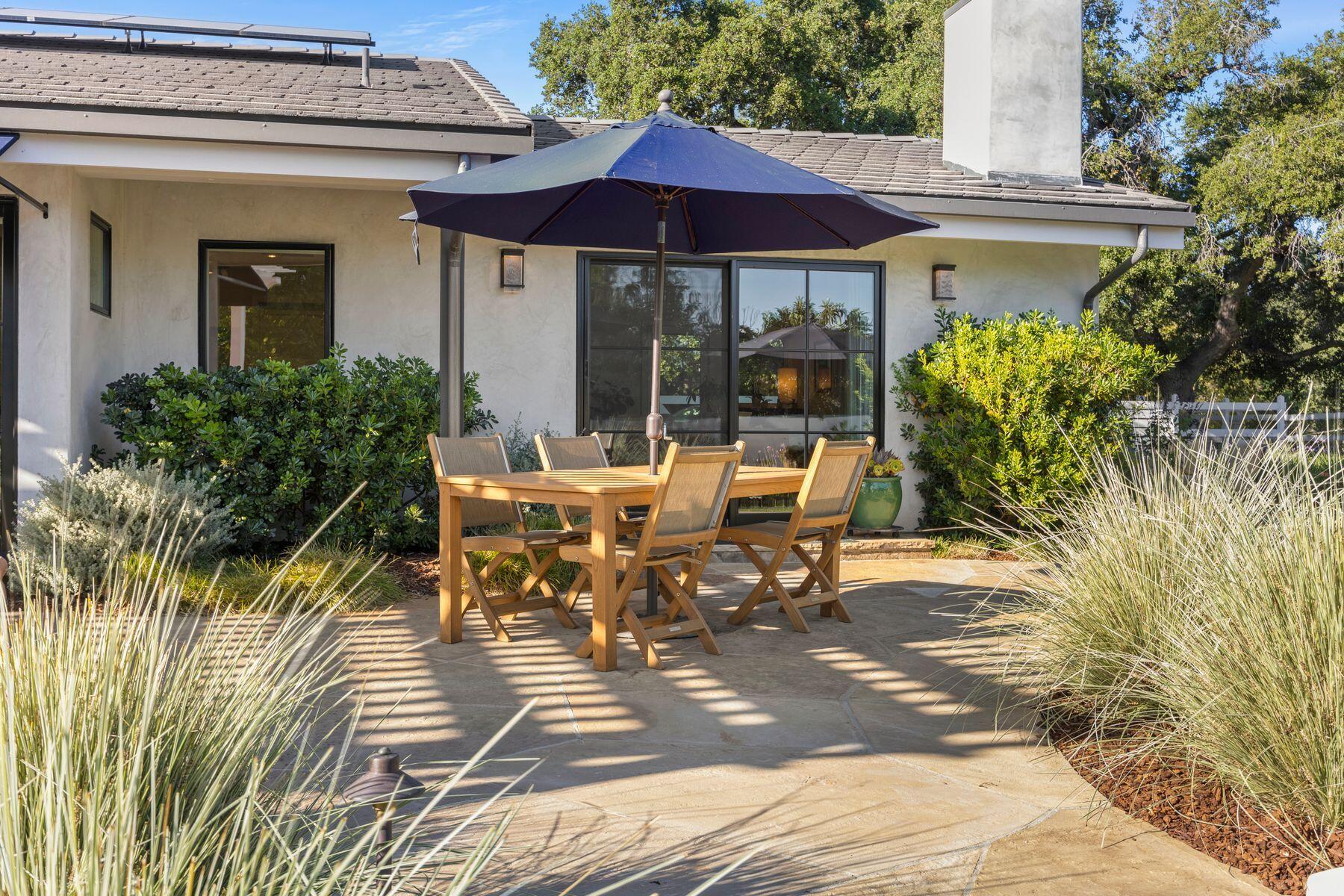 10929 Encino Drive Oak View, CA 93022 - Photo 42 of 50 a view of a patio with table and chairs under an umbrella