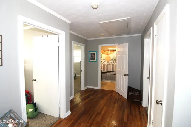 a view of a hallway with wooden floor and closet