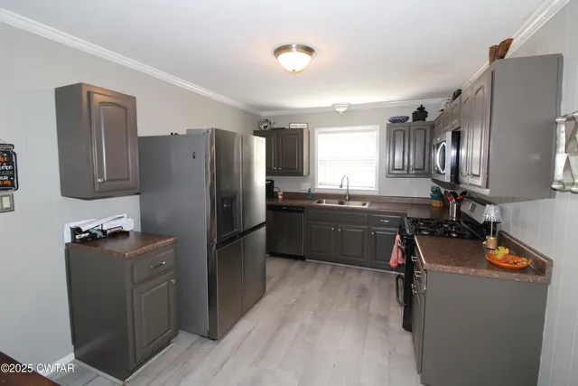 a kitchen with stainless steel appliances a refrigerator stove and sink