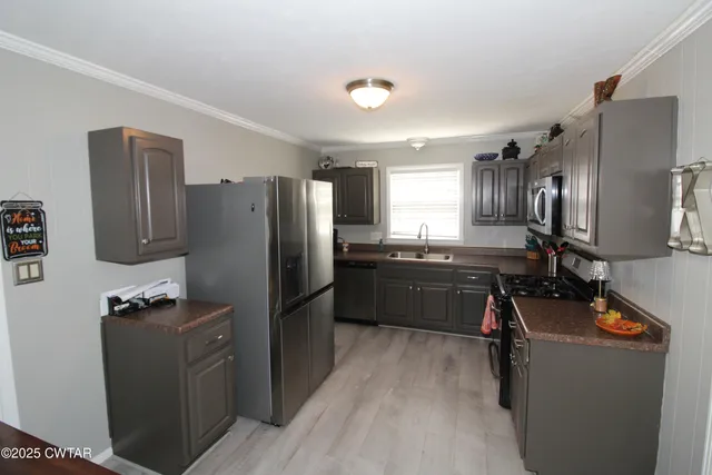 a kitchen with refrigerator cabinets and wooden floor