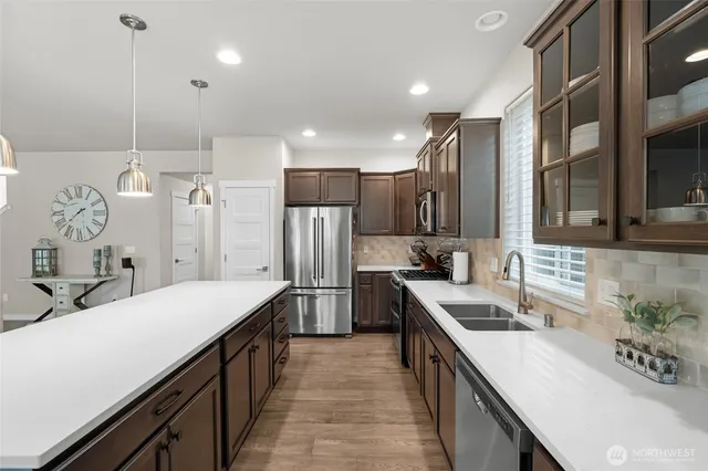 a kitchen with stainless steel appliances granite countertop a sink a stove and a refrigerator