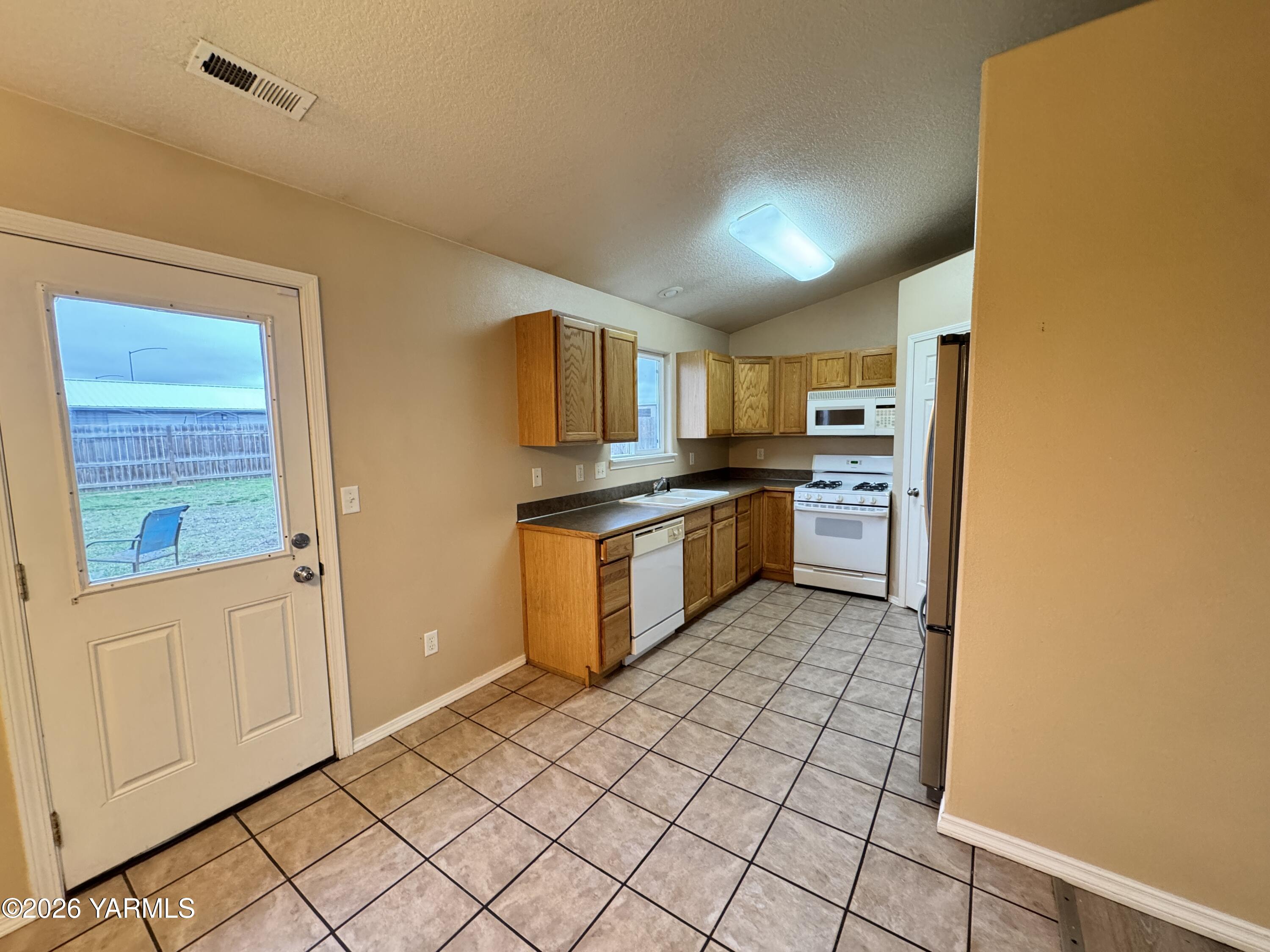 815 Jessica Court Grandview, WA 98930 - Photo 14 of 27 a kitchen with stainless steel appliances granite countertop a refrigerator and a stove top oven