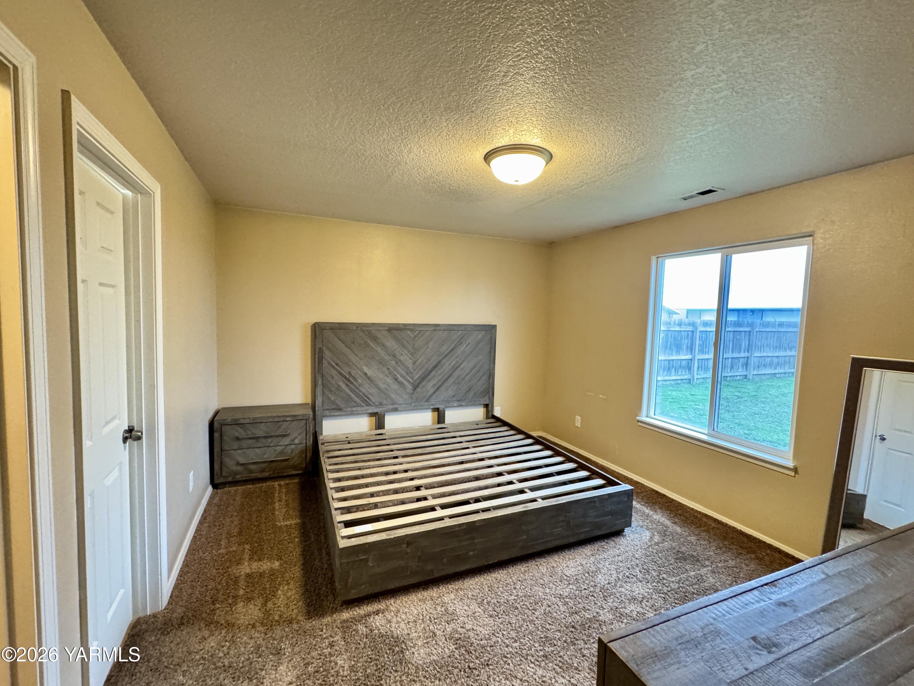 815 Jessica Court Grandview, WA 98930 - Photo 6 of 27 a bedroom with a bed and wooden floor