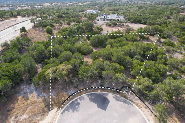 an aerial view of a house with a yard and lake view