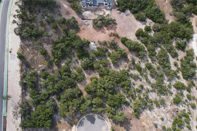 an aerial view of residential house with outdoor space and trees all around