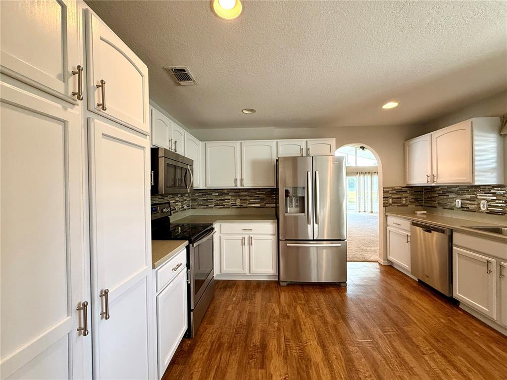 15235 Southwest 14th Avenue Road Ocala, FL 34473 - Photo 14 of 52 a kitchen with a refrigerator a sink and dishwasher with wooden floor