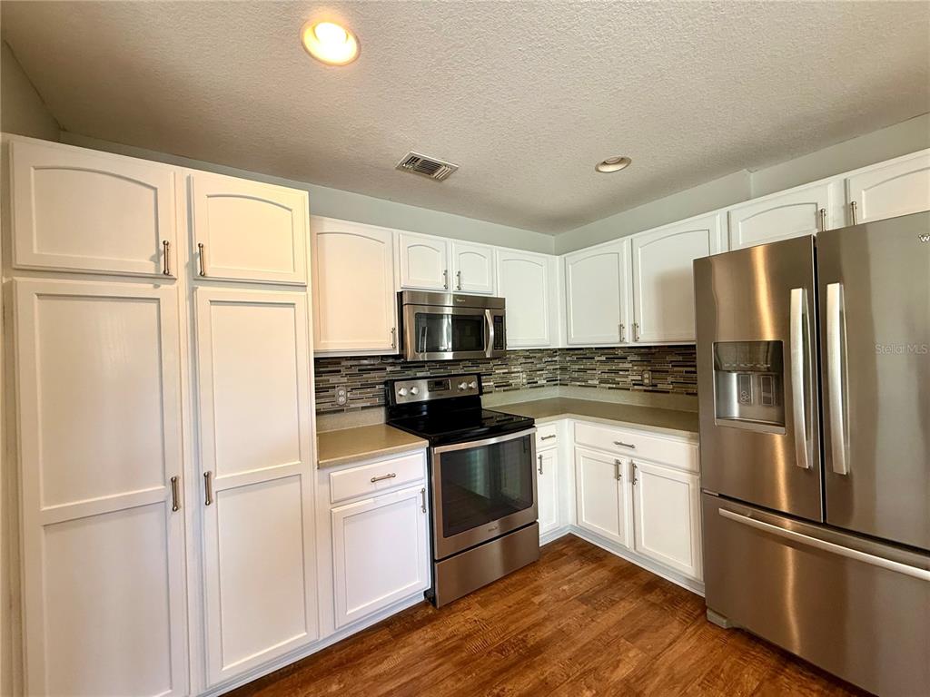 15235 Southwest 14th Avenue Road Ocala, FL 34473 - Photo 17 of 52 a kitchen with granite countertop stainless steel appliances and wooden floor