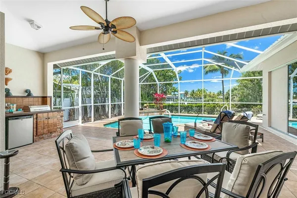 a dining room with furniture large windows and a chandelier