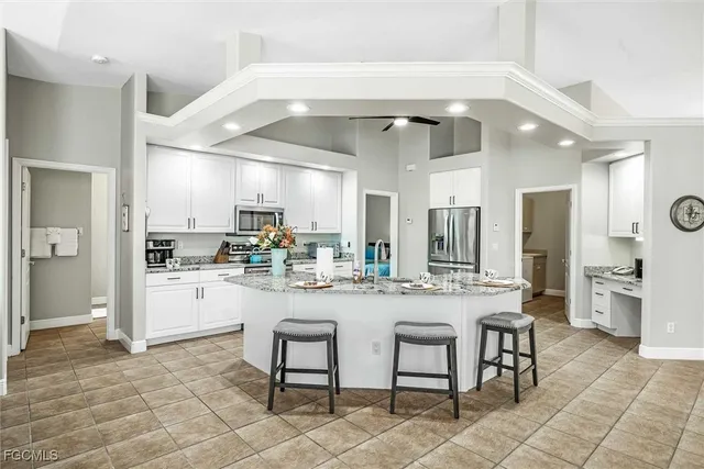 a kitchen with a dining table chairs cabinets and stainless steel appliances