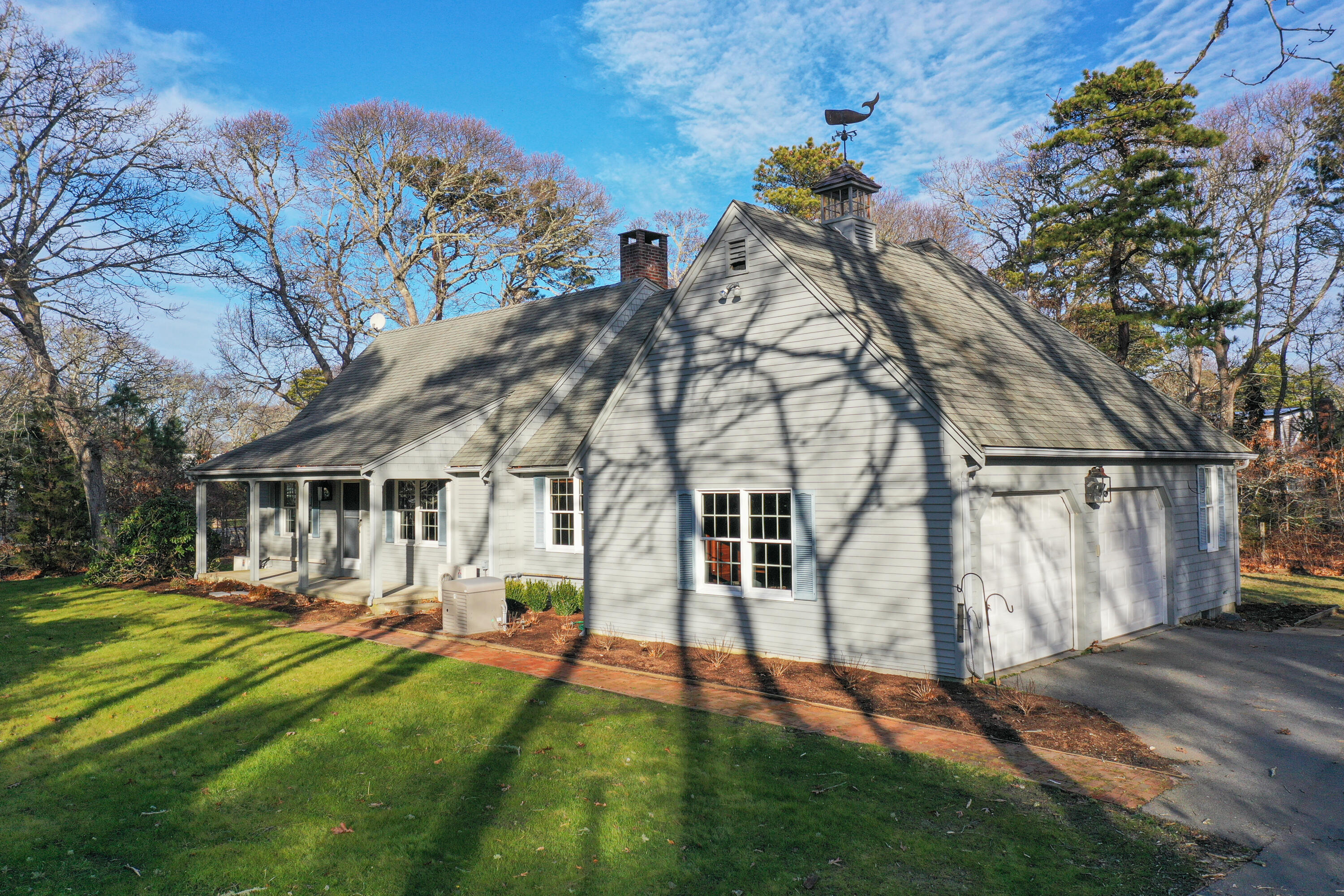 40 Baldwin Road Eastham, MA 02642 - Photo 10 of 37 a view of a white house next to a yard with big trees