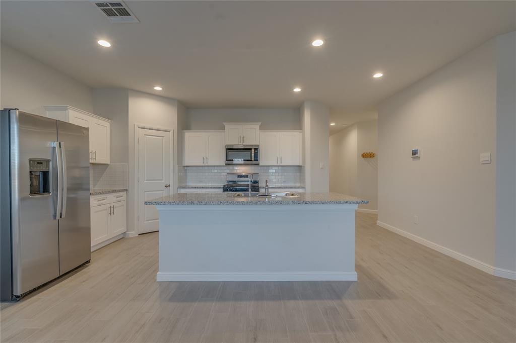 9645 Alderleaf Trail Crowley, TX 76036 - Photo 14 of 33 a view of kitchen with stainless steel appliances granite countertop cabinets and wooden floor