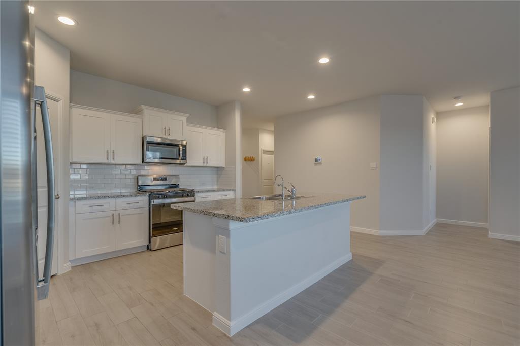 9645 Alderleaf Trail Crowley, TX 76036 - Photo 15 of 33 a kitchen with kitchen island sink stove and cabinets