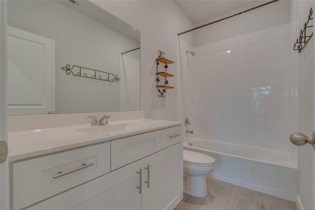9645 Alderleaf Trail Crowley, TX 76036 - Photo 9 of 33 a bathroom with a granite countertop sink a toilet and a bathtub