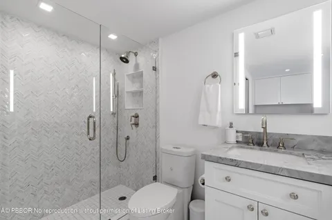 a bathroom with a granite countertop double vanity sink and mirror