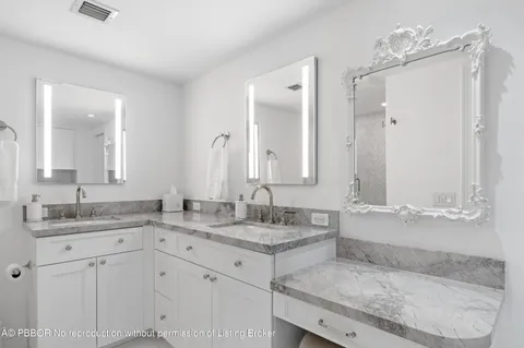 a bathroom with a granite countertop sink mirror and toilet