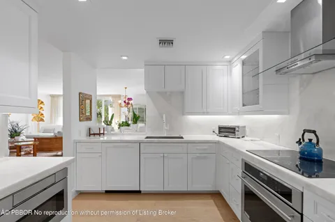 a kitchen with white cabinets stainless steel appliances and sink