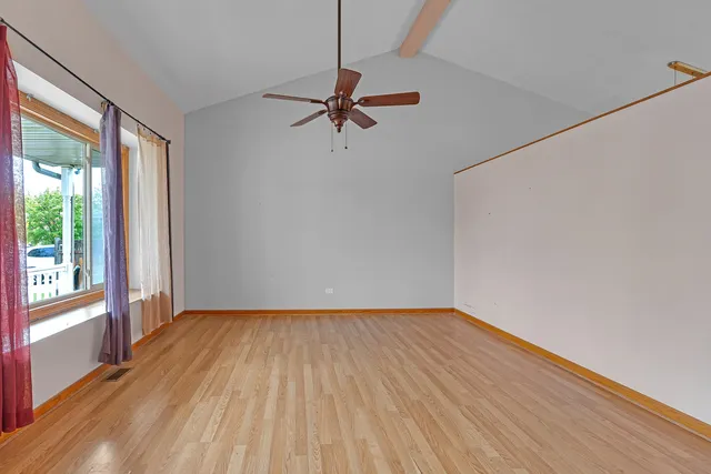 a view of a room with wooden floor and fan