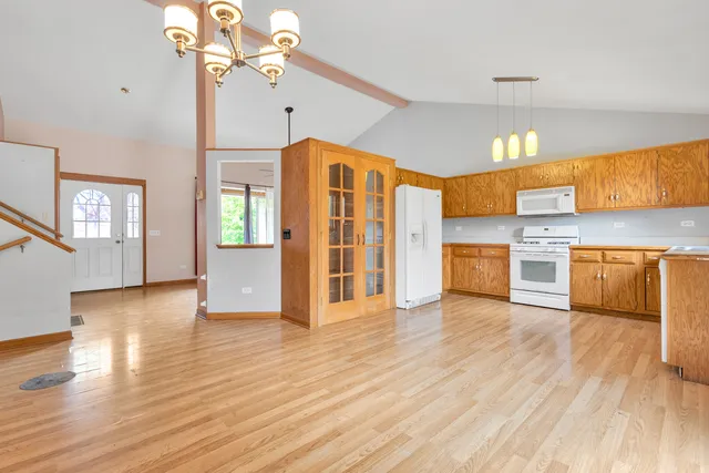 a view of a kitchen with a kitchen island wooden floor and stainless steel appliances