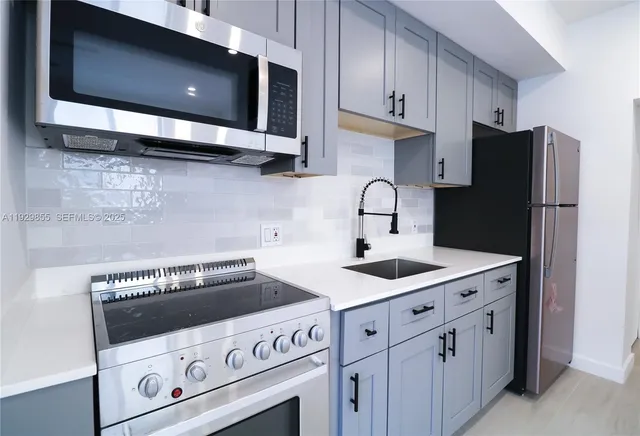 a kitchen with granite countertop a stove microwave and sink