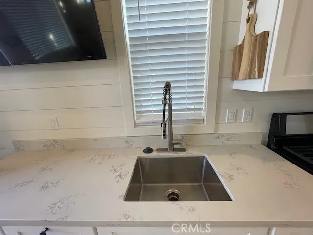 a kitchen with a sink and a stove with wooden floor