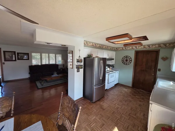 a living room with furniture and a refrigerator