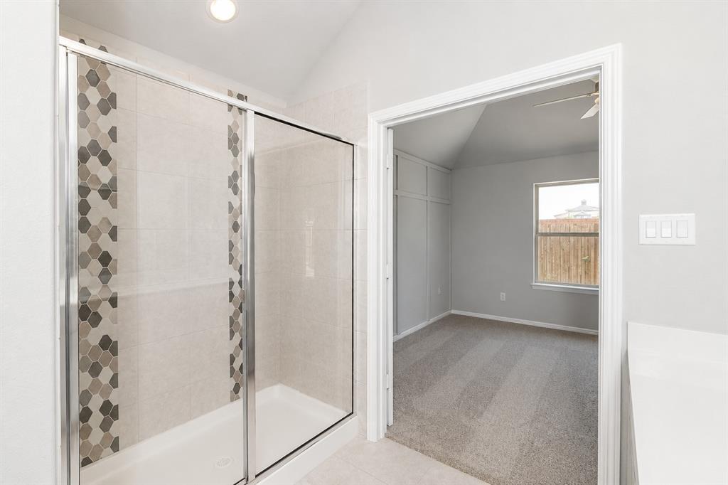3344 Duncan Way Corinth, TX 76210 - Photo 16 of 38 Shower enclosure with sliding glass doors, white tiled walls, and decorative mosaic tile accent