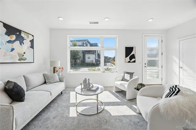 a living room with furniture and a painting on the wall