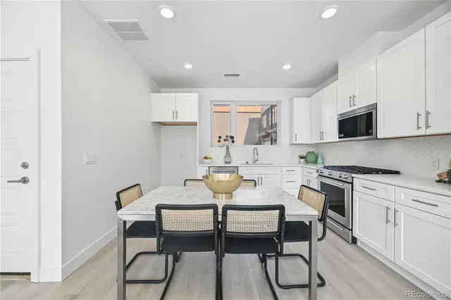 a view of kitchen with cabinets table and chairs