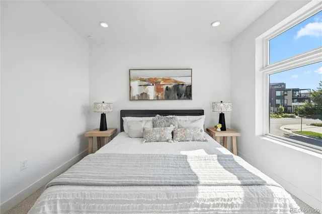 a bedroom with a large bed and a painting on the wall