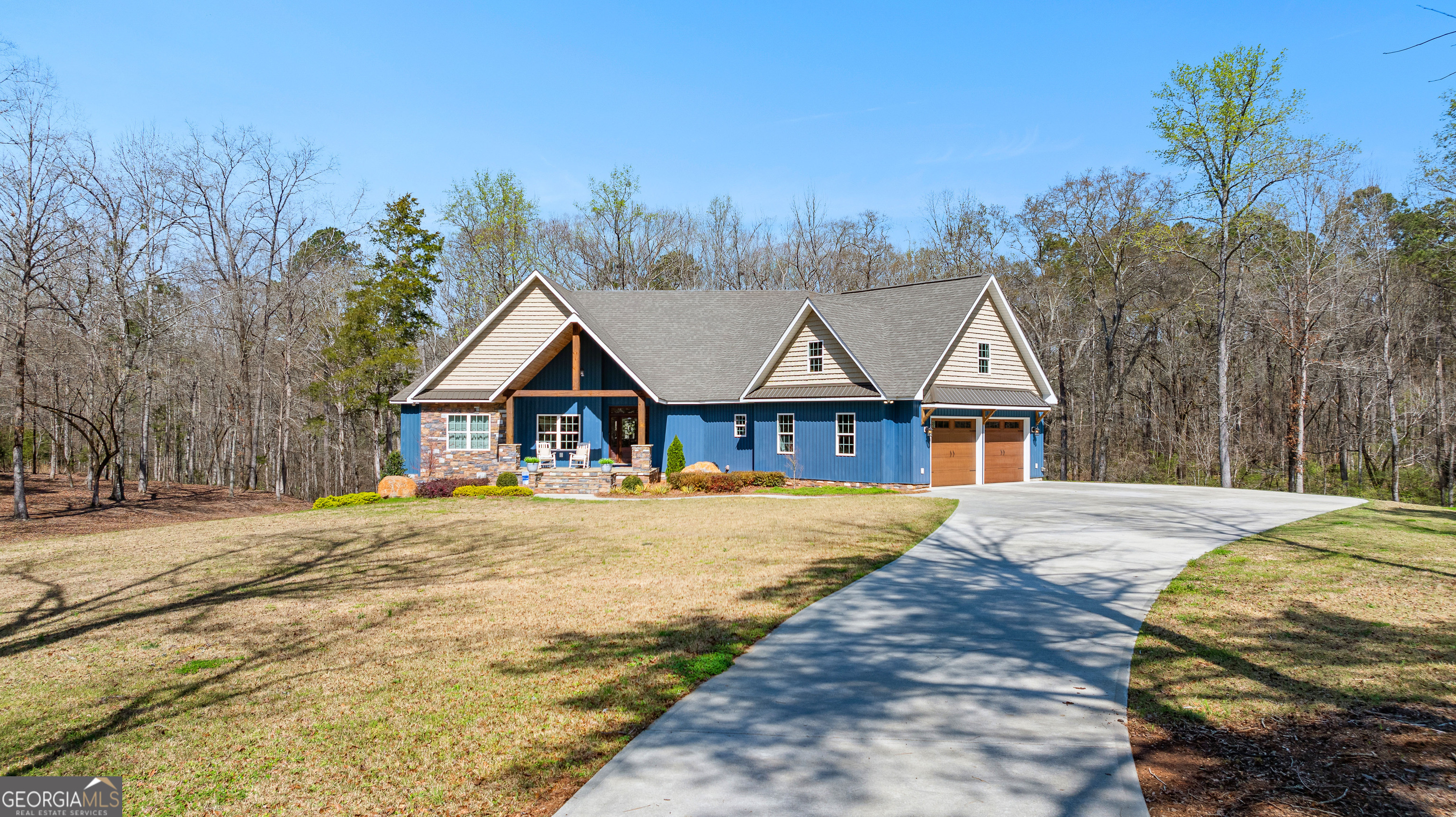 a front view of a house with a yard and trees