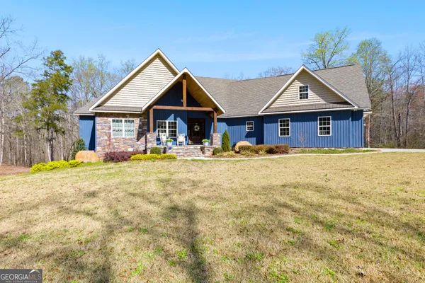 a view of house with yard and trees in the background