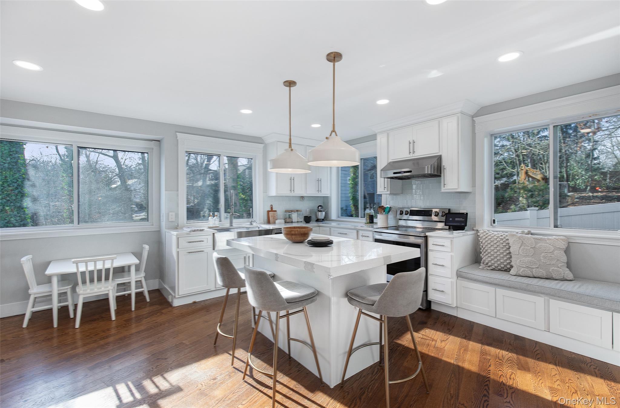 25 Roxbury Road Scarsdale, NY 10583 - Photo 9 of 32 The exceptional, newly renovated, and eat-in open kitchen features a floating island, breakfast bar, dining area with built-in bench, stainless steel appliances, access to the yard, and a full bathroom.