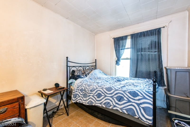 448 East 31st Street Paterson, NJ 07504 - Photo 19 of 23 a bedroom with a bed and a chair with the wooden floor