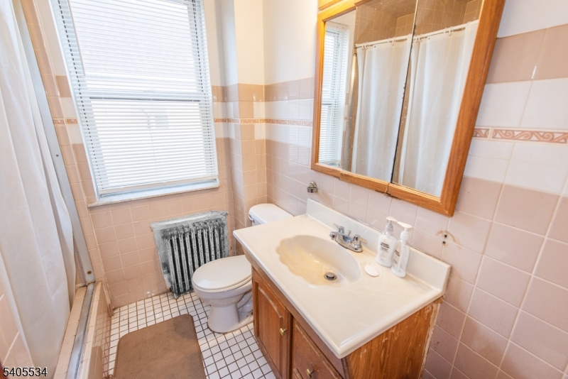 448 East 31st Street Paterson, NJ 07504 - Photo 20 of 23 a bathroom with a sink toilet and mirror