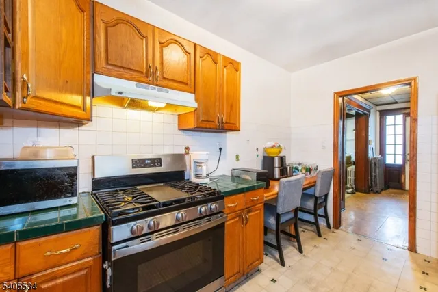 a kitchen with stainless steel appliances granite countertop a stove a sink and a microwave