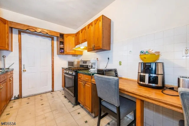 a kitchen with stainless steel appliances granite countertop a sink and a refrigerator