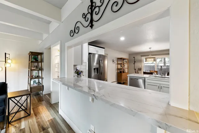 a large white kitchen with a large window and stainless steel appliances