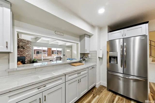 a kitchen with stainless steel appliances a refrigerator a sink and white cabinets