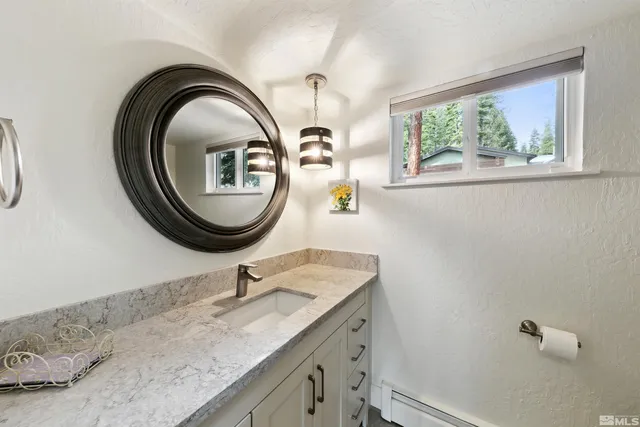 a bathroom with a granite countertop a sink and a mirror