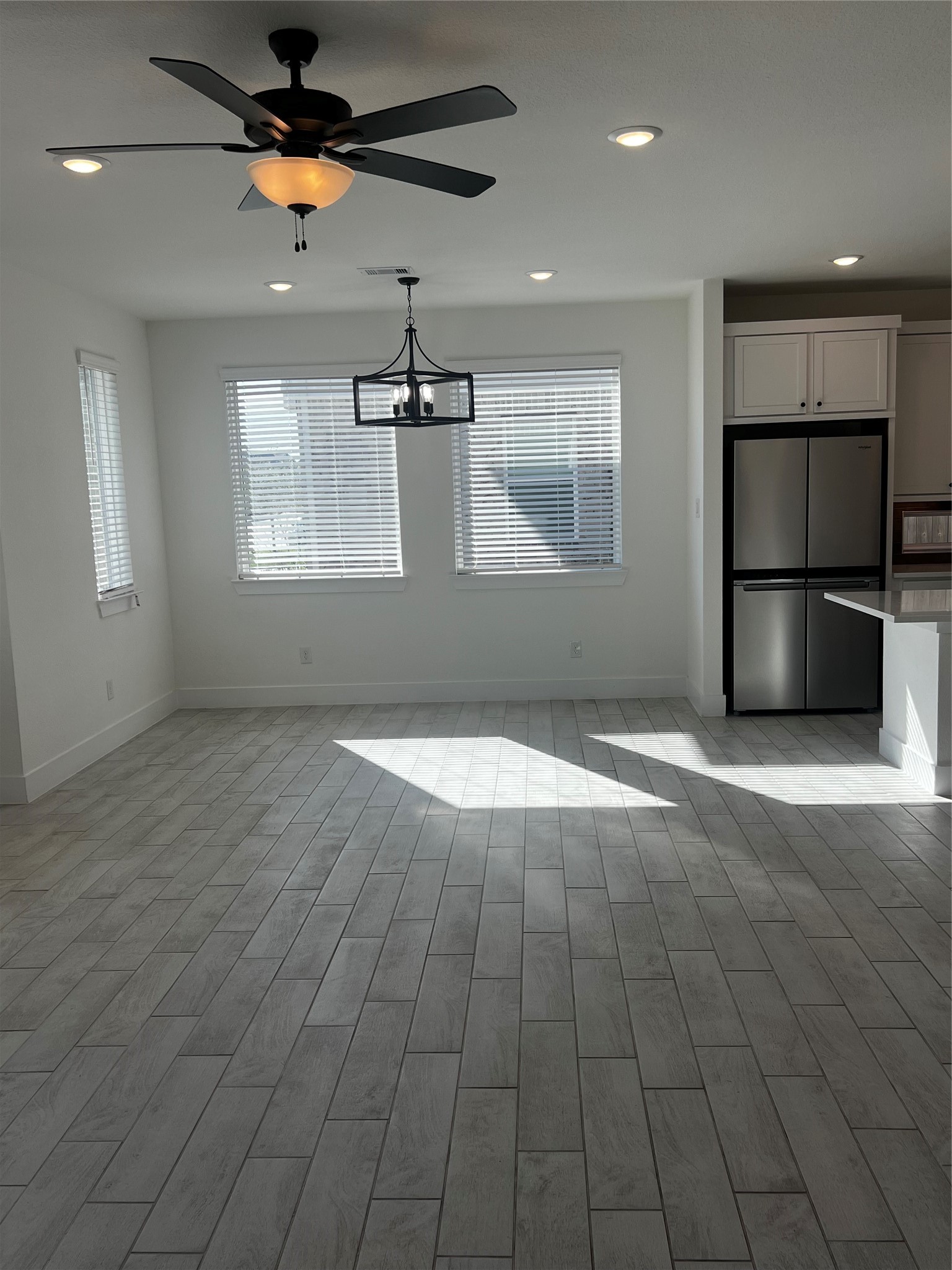 7743 Swooping Swallow Lane Katy, TX 77493 - Photo 16 of 45 an empty room with windows and chandelier fan